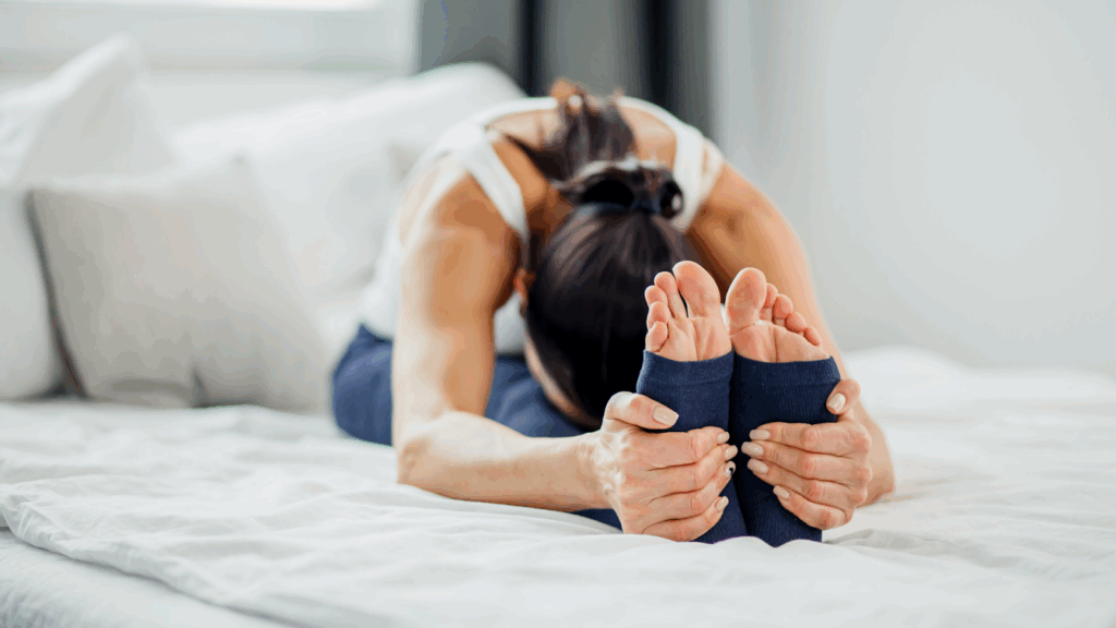 Woman stretching her hamstrings and calves on the bed