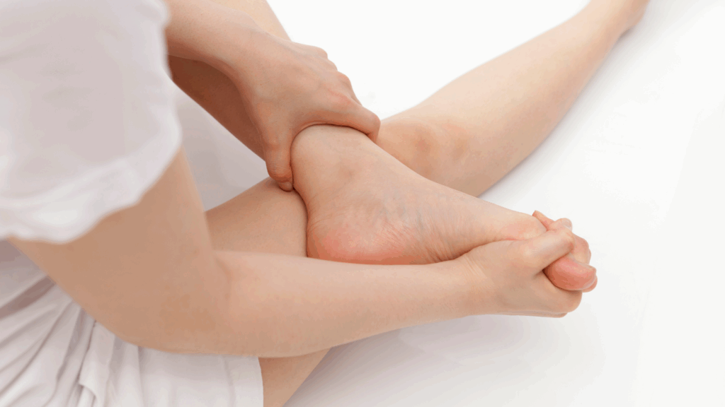 Person holding foot and stretching plantar fascia to relieve pain at home.