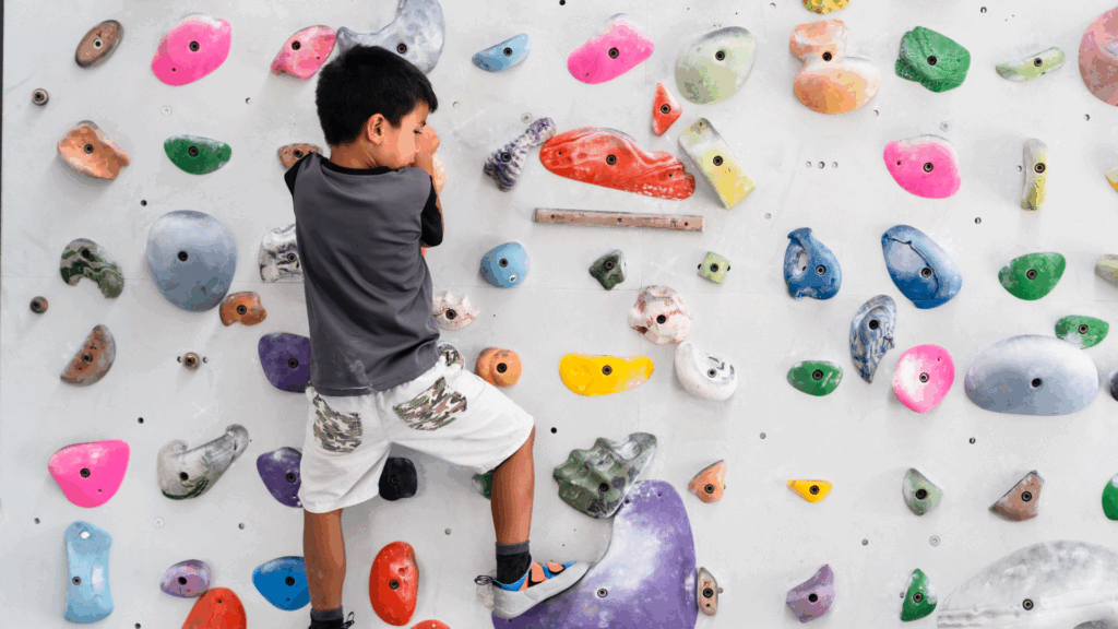 Child with pigeon toe strengthening legs through indoor rock climbing
