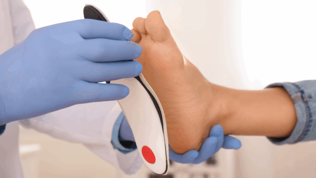 Podiatrist fitting a custom orthotic insole to a patient’s foot.