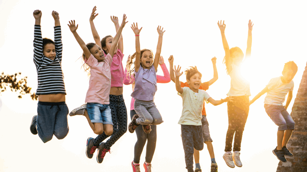 Happy group of children jumping outdoors after overcoming pigeon toe concerns