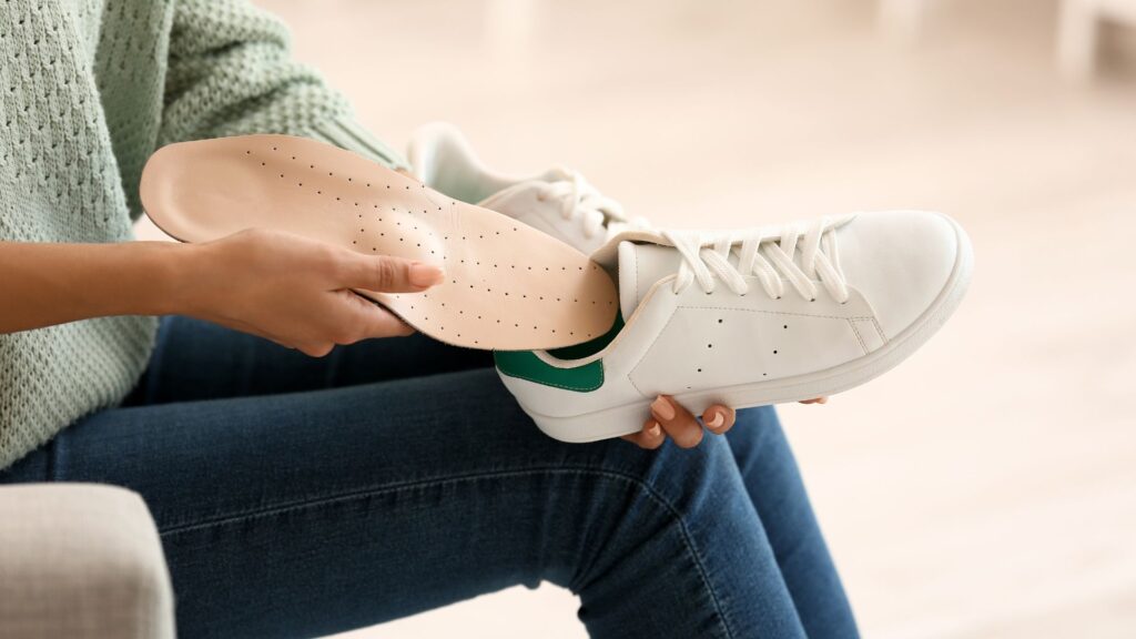 Podiatrist fitting custom orthotics for a patient to improve foot alignment and relieve pain in Singapore