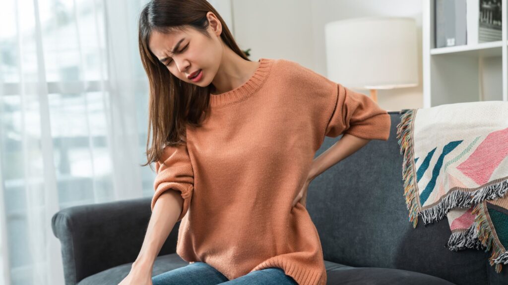 Woman experiencing lower back pain from poor foot posture, improved with orthotics support