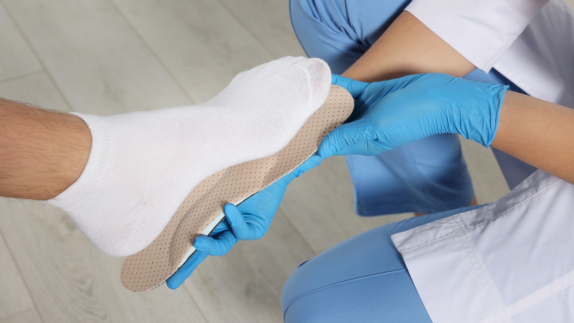 An older woman sitting on a sofa using her phone, representing individuals learning about chronic foot pain or high-arched feet symptoms.