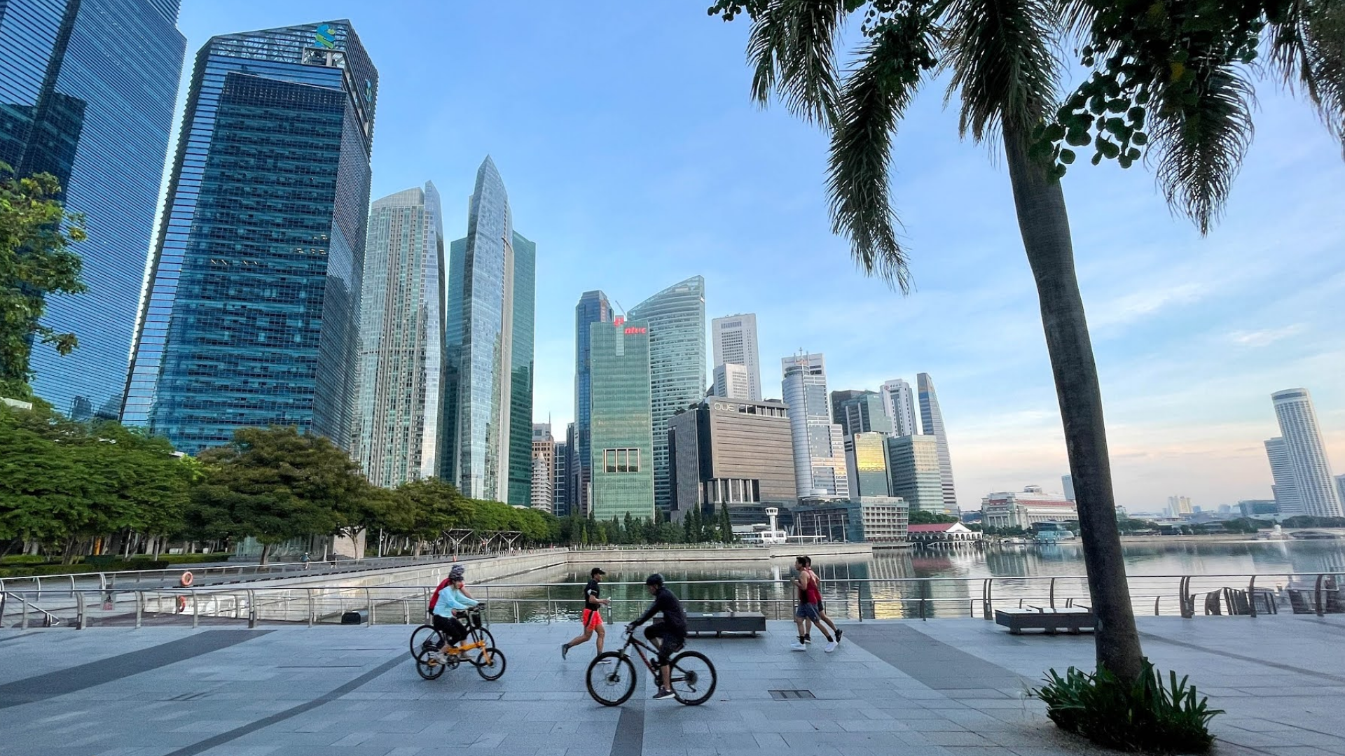 Runners and cyclists along Marina Bay with Singapore’s CBD skyline, a popular city route known for hard, flat, and hot running conditions in Singapore.