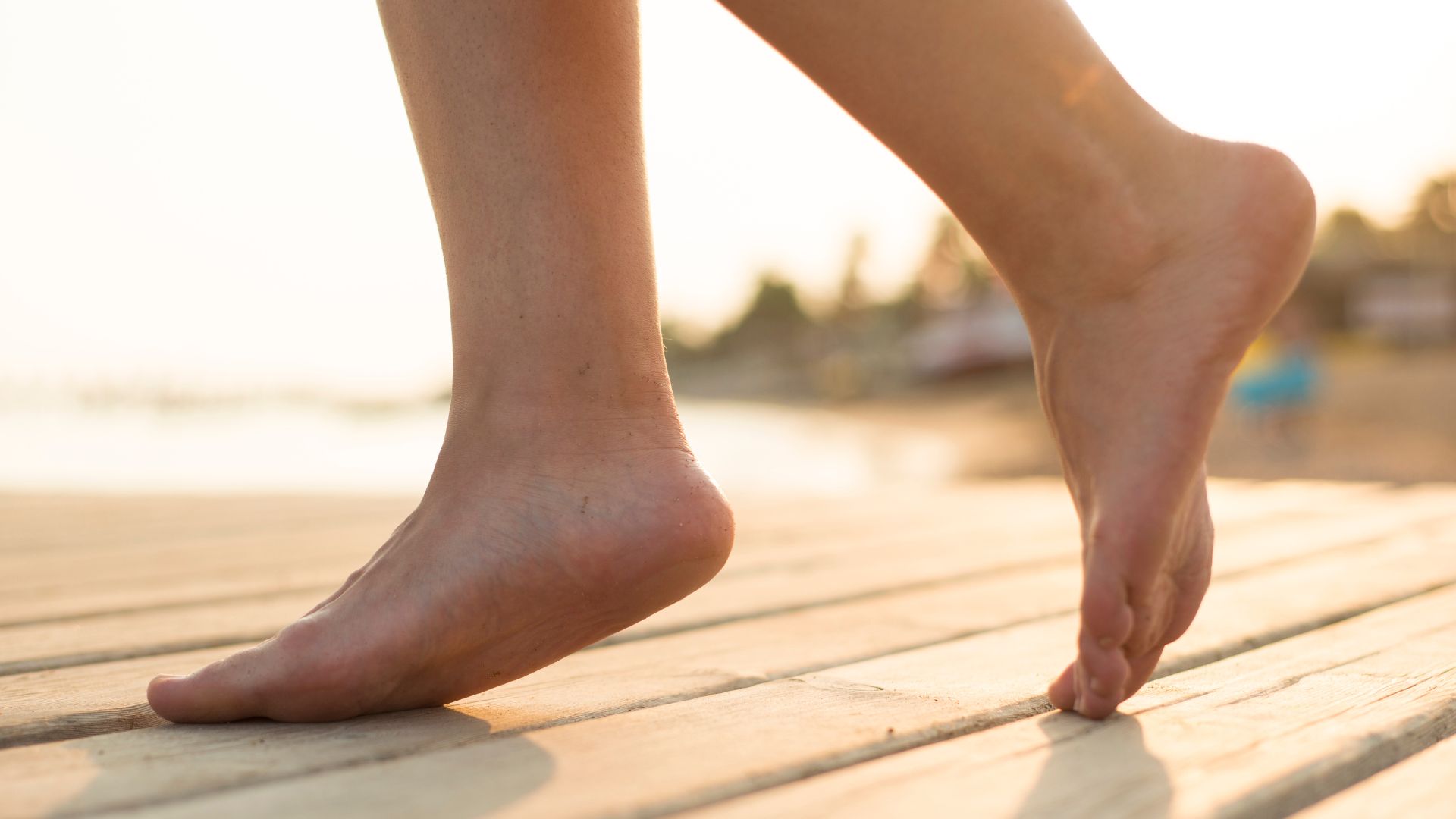 A person walking outdoors on their toes with visible high arches, illustrating gait patterns commonly seen in people with pes cavus.