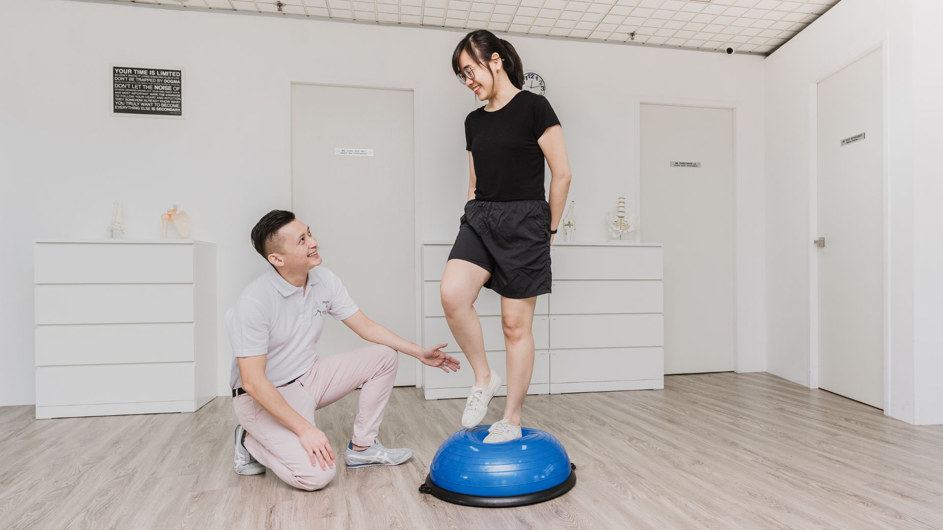 A physiotherapist coaching a patient on a Bosu ball to improve balance, strength, and rehabilitation.