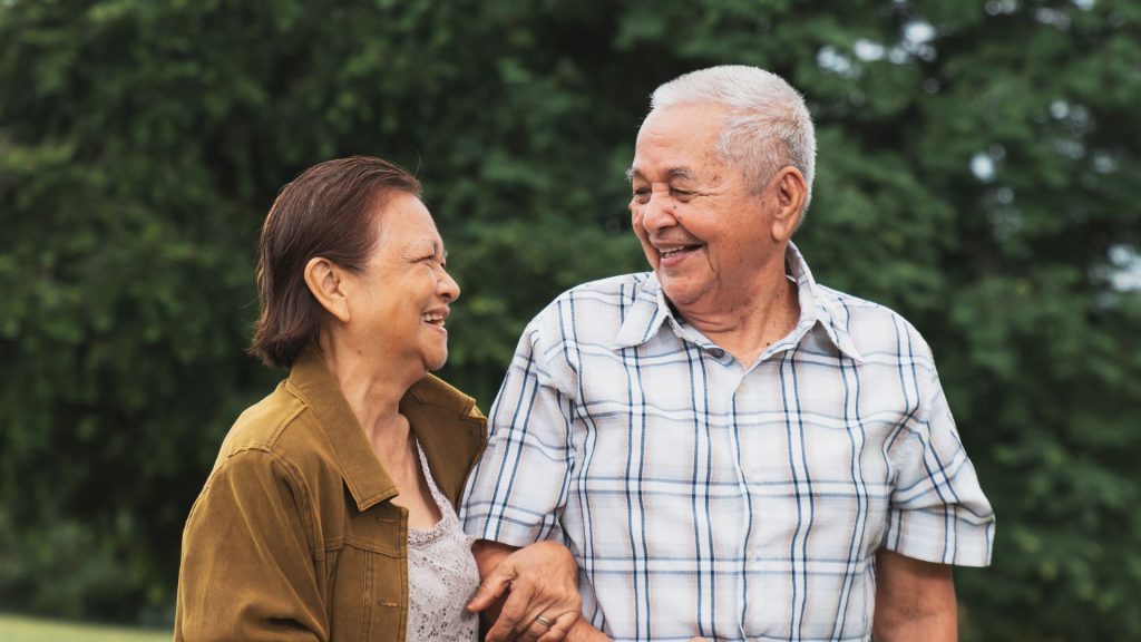 Elderly couple walking comfortably outdoors, highlighting importance of healthy feet and mobility