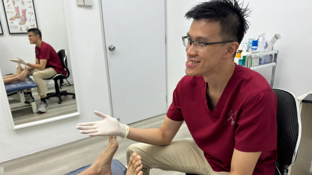 Podiatrist explaining treatment options to a patient during a clinic consultation.
