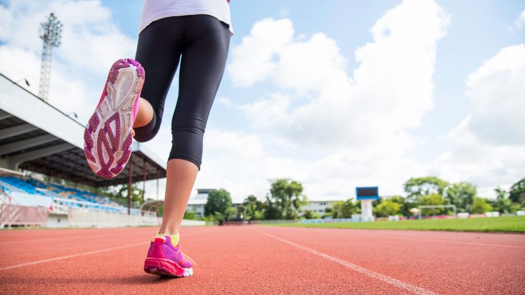 Runner slowing down on a track, representing early warning signs of foot pain after running