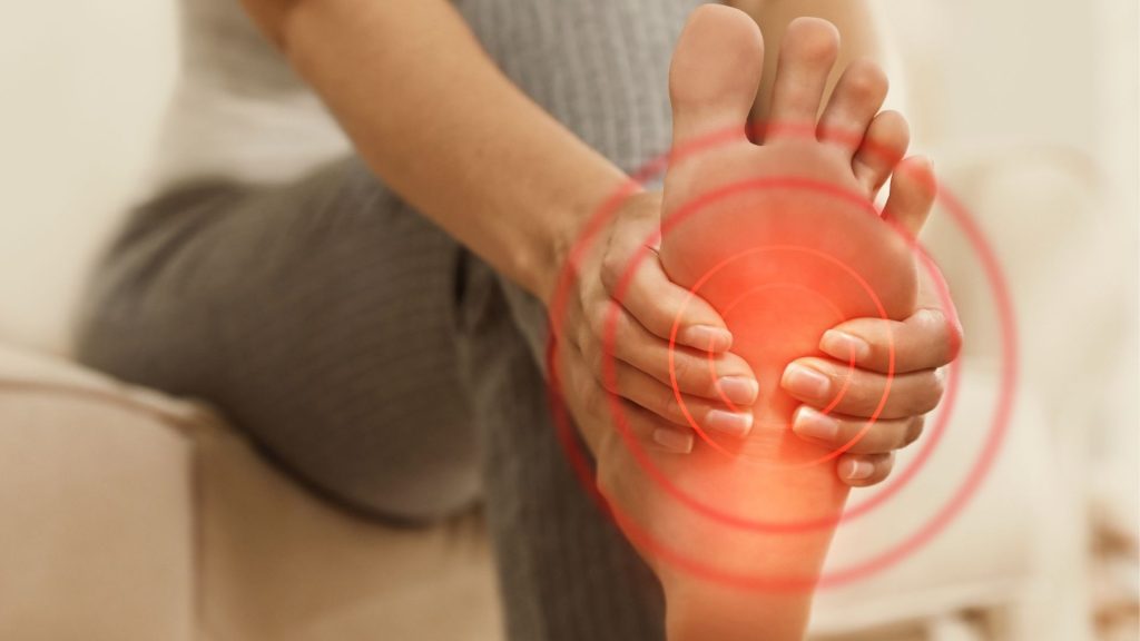 Runner holding the sole of the foot with highlighted pain area, showing foot aches after running due to overload