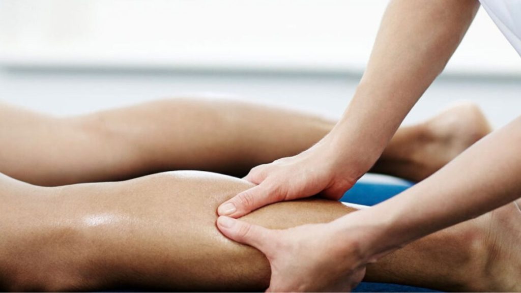 Physiotherapist performing hands-on massage therapy on a patient’s leg to relieve muscle tension and improve circulation as part of physiotherapy care.