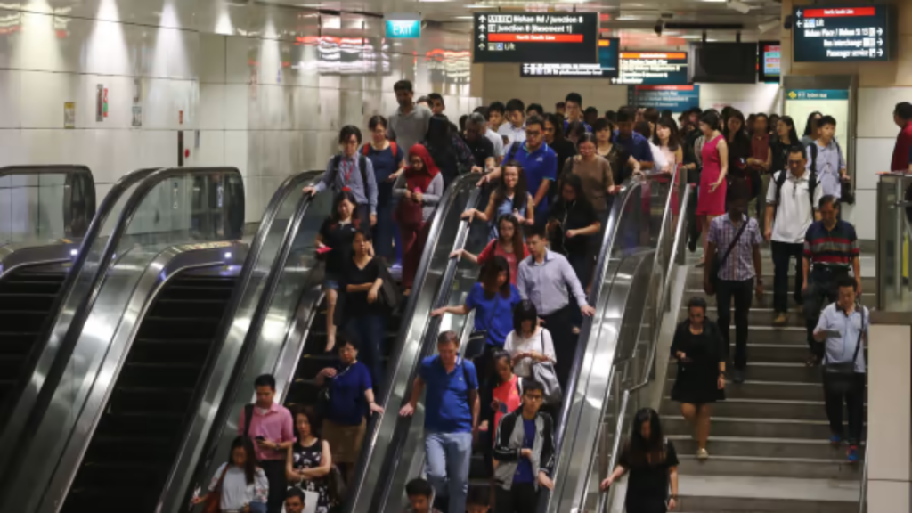 Crowded Singapore MRT station with commuters walking and standing during daily travel.