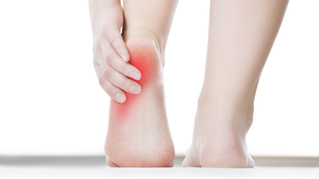 Person holding the heel to indicate discomfort at the back of the foot