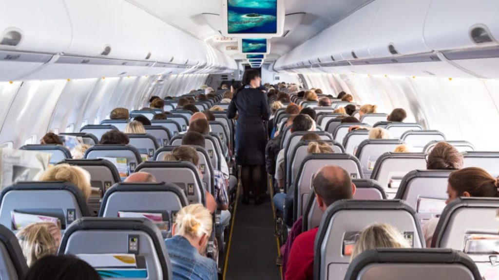 Passengers seated inside an airplane cabin during a flight, illustrating long periods of sitting and time spent in shoes while travelling.