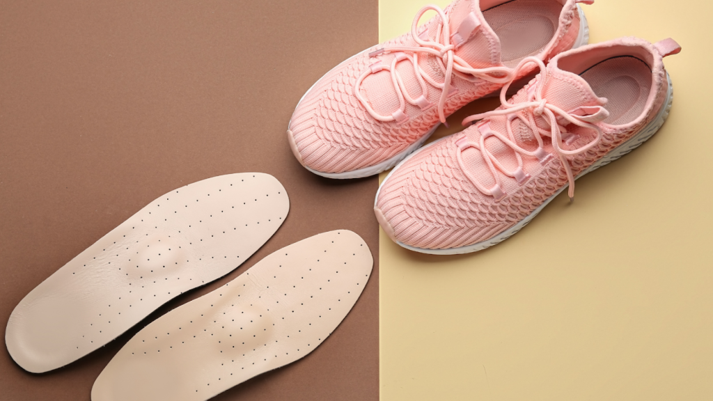 Children’s sneakers next to custom insoles, showing foot support options used in podiatry care.