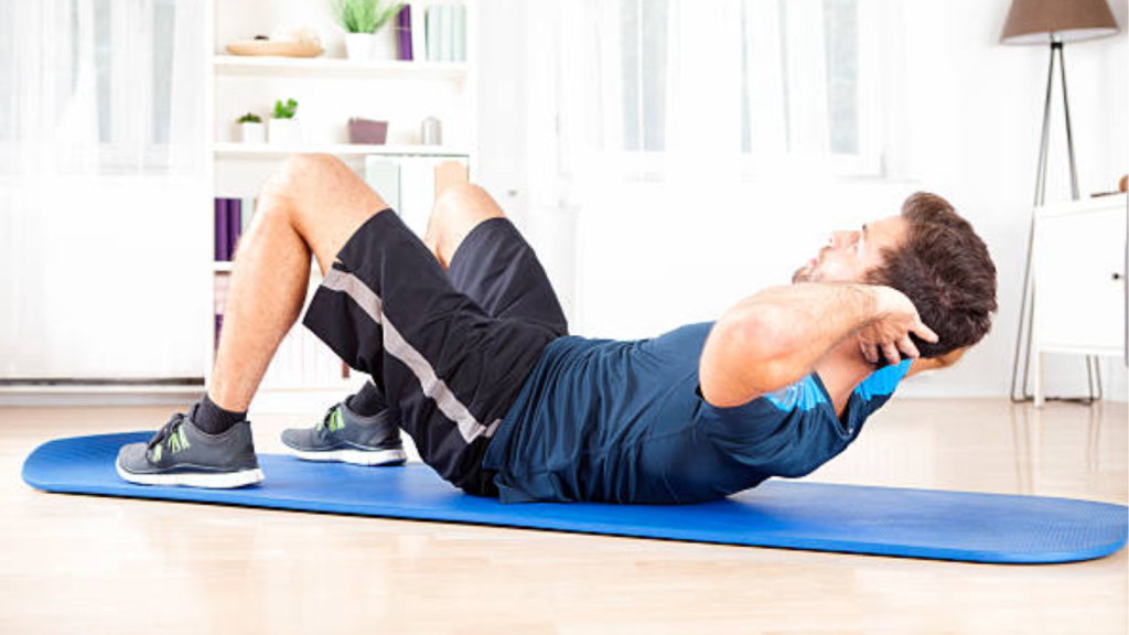 Man performing a sit-up exercise on a mat at home.
