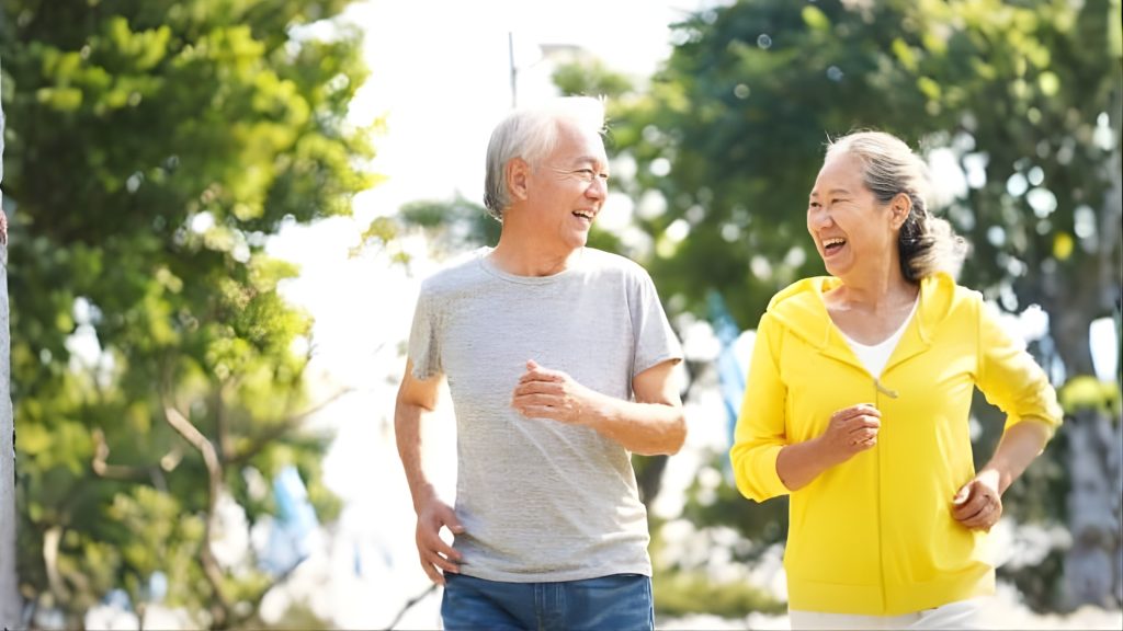 Active elderly couple jogging outdoors, representing improved mobility and physical function after physiotherapy.
