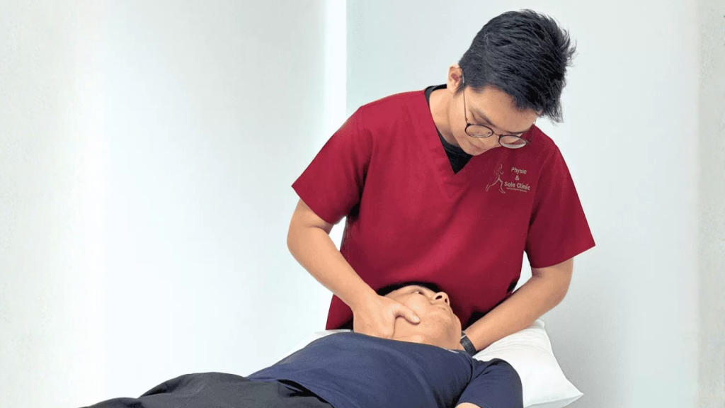 Physiotherapist performing manual therapy on a patient’s neck at Physio & Sole Clinic Singapore