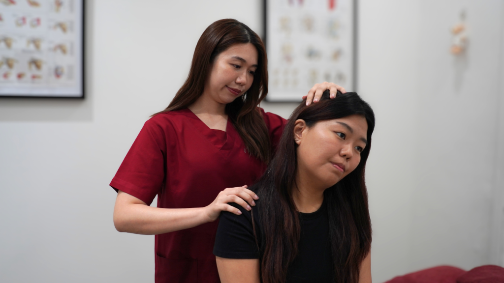 Physiotherapist assessing neck mobility and posture during manual therapy session at Physio & Sole Clinic Singapore