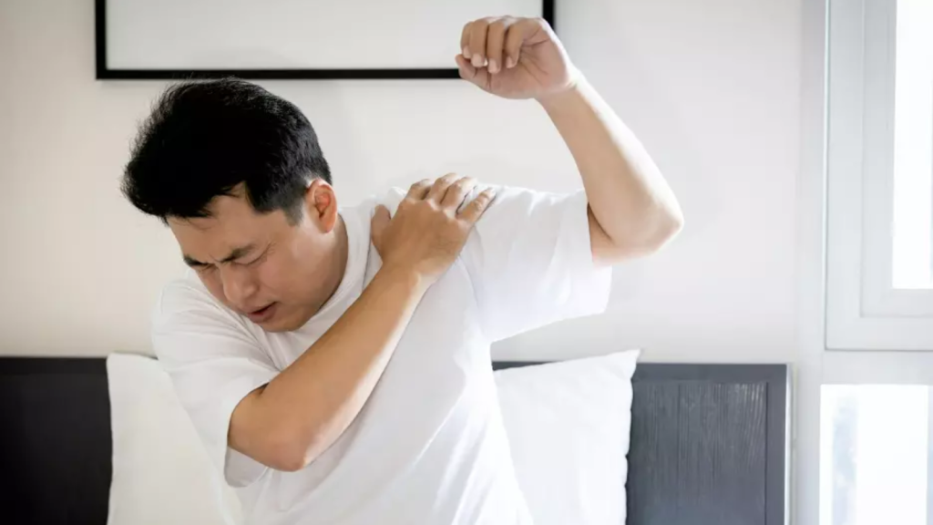 Man experiencing shoulder and upper back pain at home