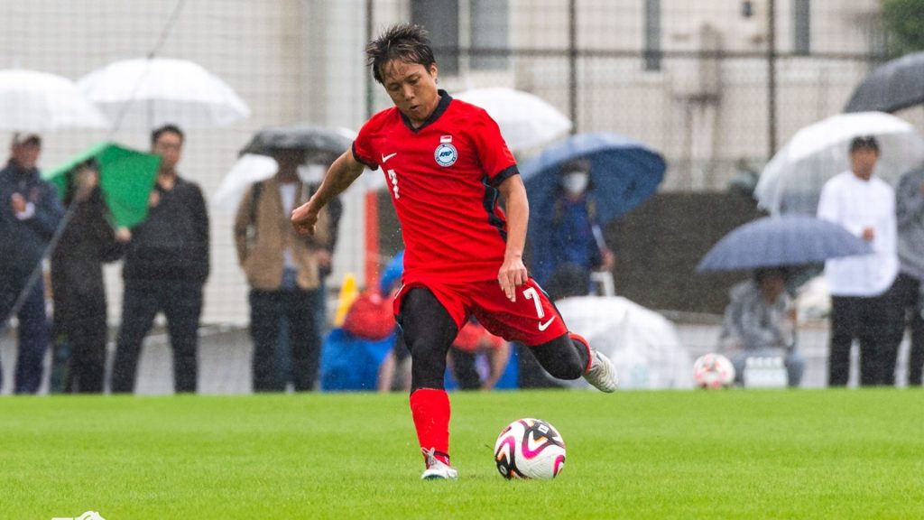 Football player striking ball during match, illustrating ACL injury risk in sports.
