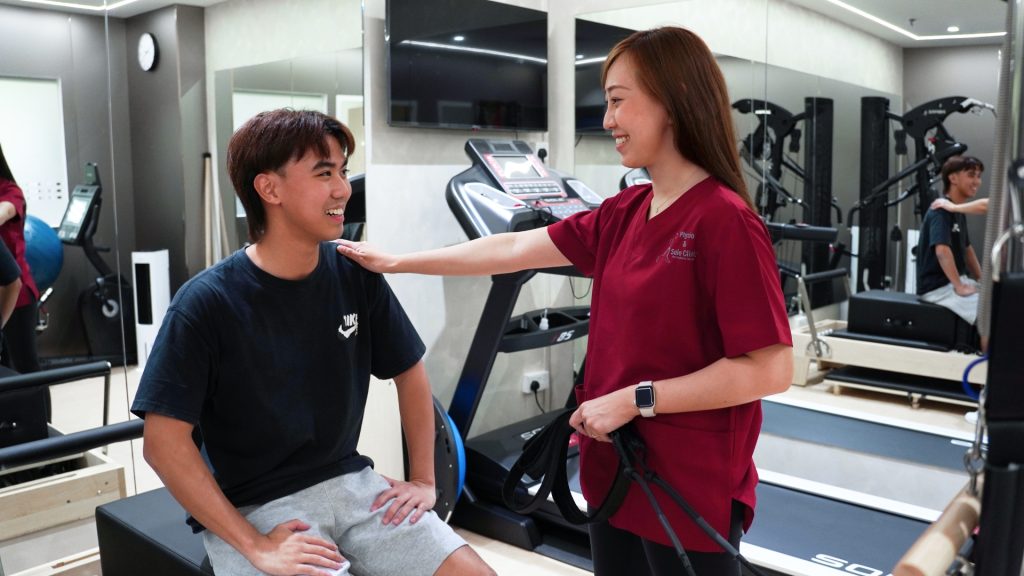 Physiotherapist encouraging patient during rehab session in gym after ACL recovery exercises.
