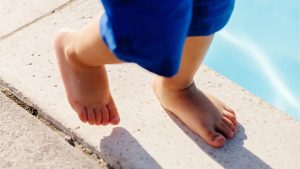 child walking barefoot showing early foot development signs parents should monitor before seeing a podiatrist in Singapore