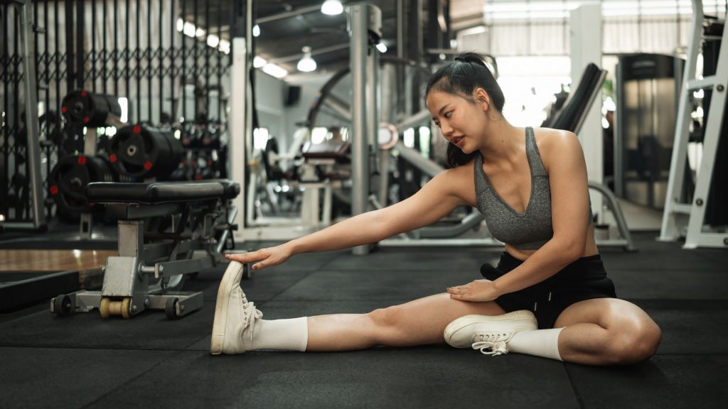 Runner stretching legs and feet before training to prevent running foot pain and improve flexibility for long distance running