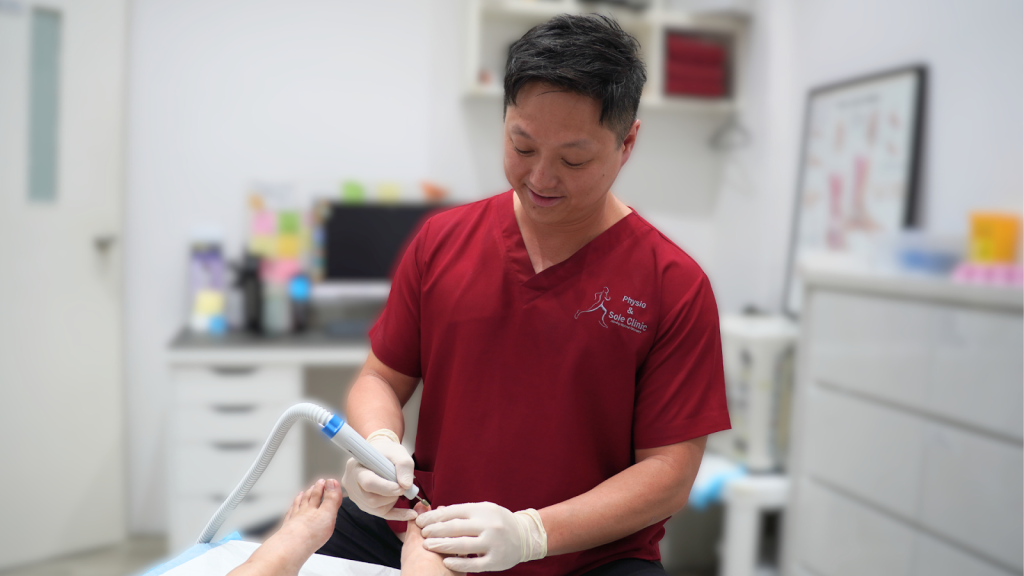 podiatrist in Singapore performing medical foot care treatment on a patient’s toenail at a podiatry clinic