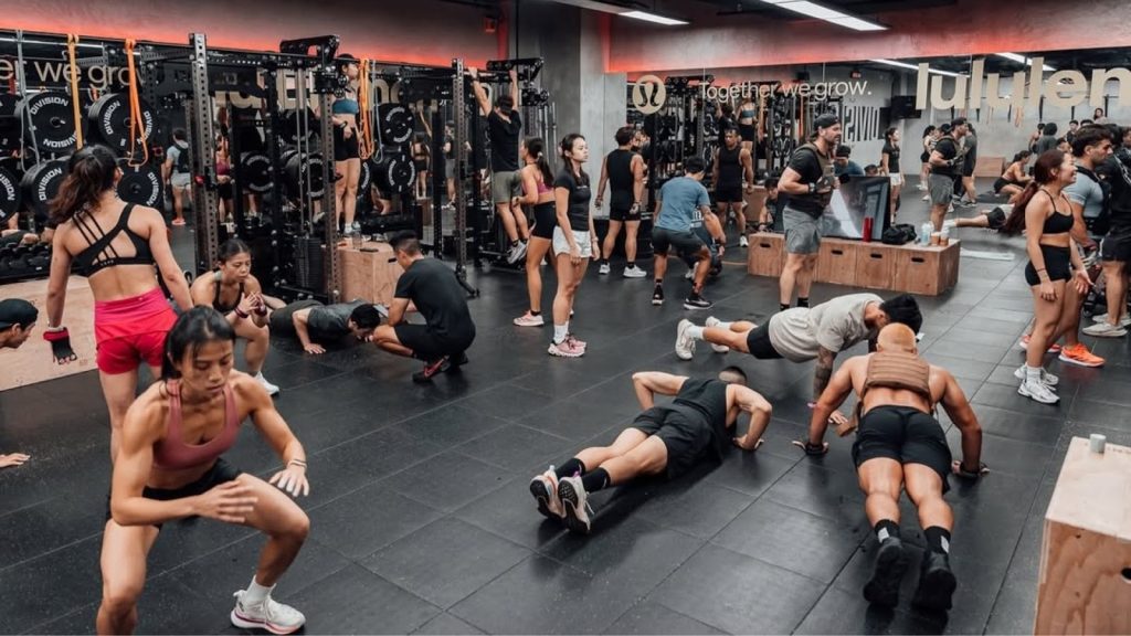 Busy gym with people doing strength and conditioning CrossFit exercises.
