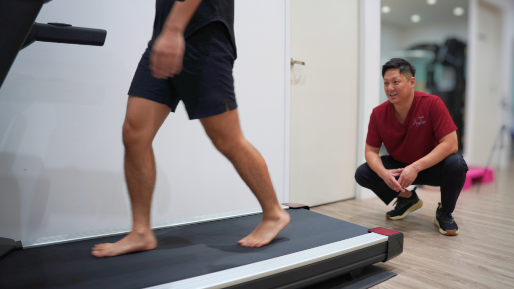 Physiotherapist performing gait analysis on a treadmill to assess walking mechanics and identify causes of chronic plantar fasciitis in a clinic setting