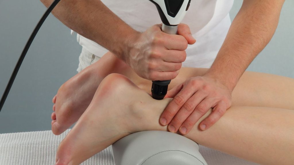 Shockwave therapy applied to ankle tendon for tendonitis treatment in clinic.
