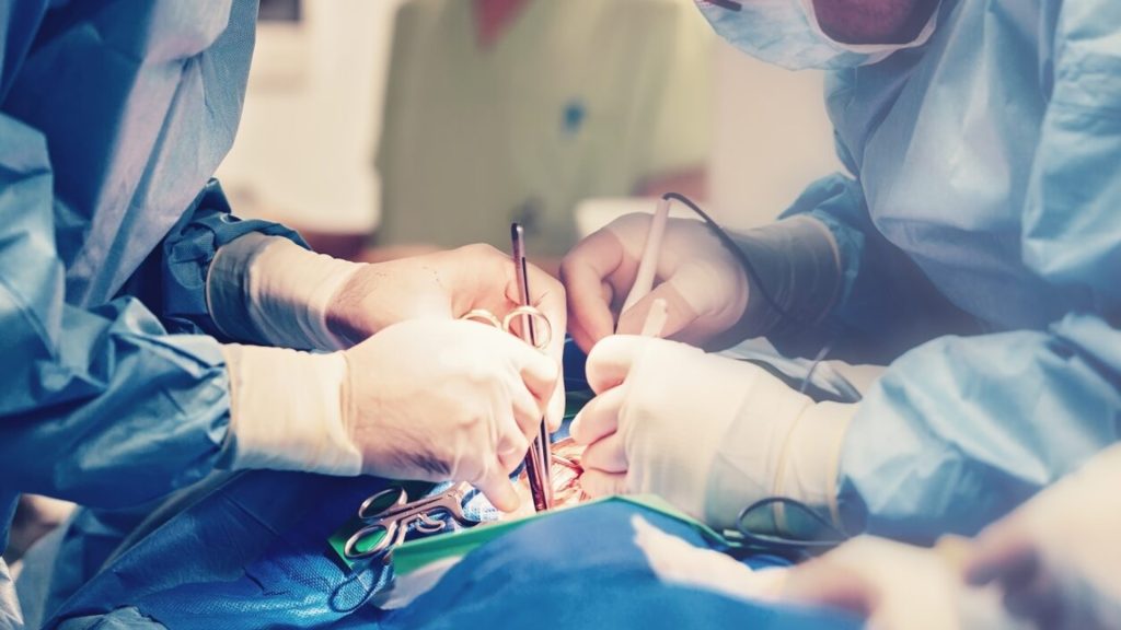 Medical team performing surgery for severe tendon injury when conservative treatment fails.
