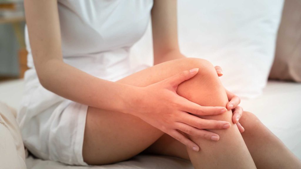person holding knee due to recurring injury that may require physiotherapy singapore