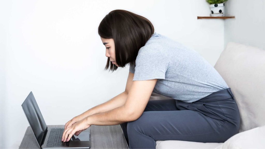 office worker sitting with poor posture causing neck and shoulder pain physiotherapy singapore