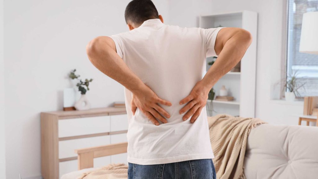 man holding lower back due to pain affecting daily activities physiotherapy singapore