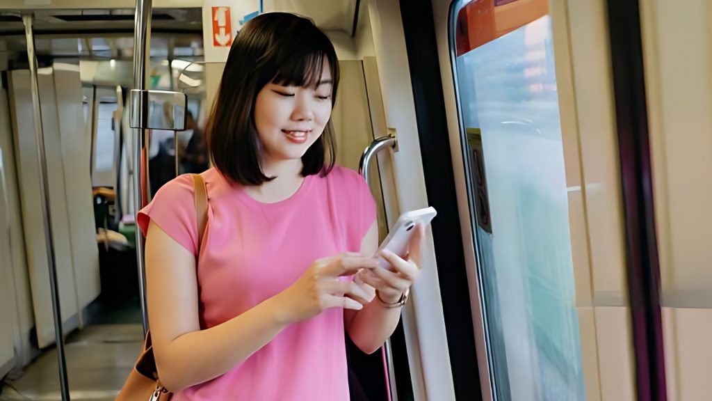 commuter using mobile phone with forward head posture increasing risk of neck pain requiring physiotherapy Singapore