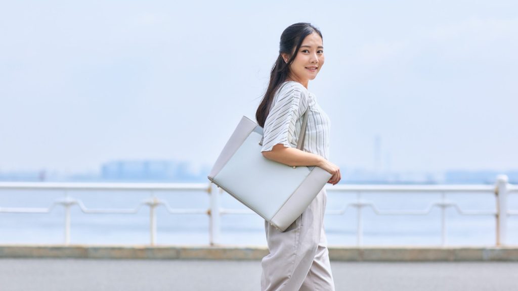 woman walking outdoors carrying handbag highlighting everyday posture habits affecting musculoskeletal health Singapore