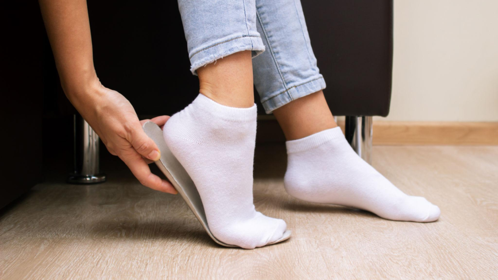 person using shoe insole for foot pain temporary relief at home