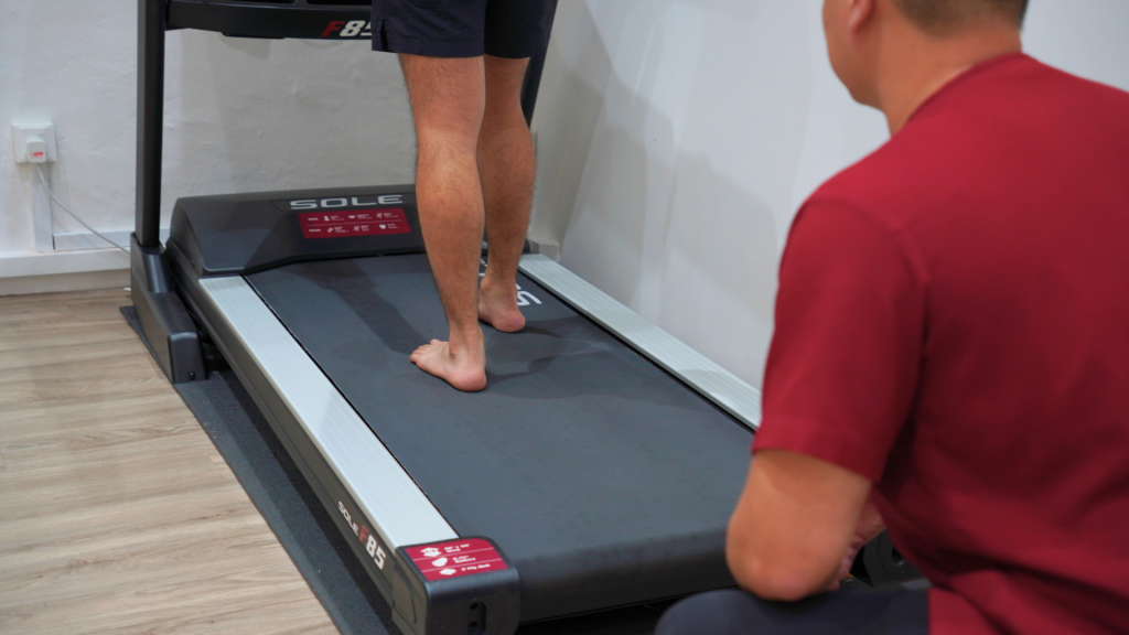 patient walking barefoot on treadmill for gait analysis, assessing foot movement