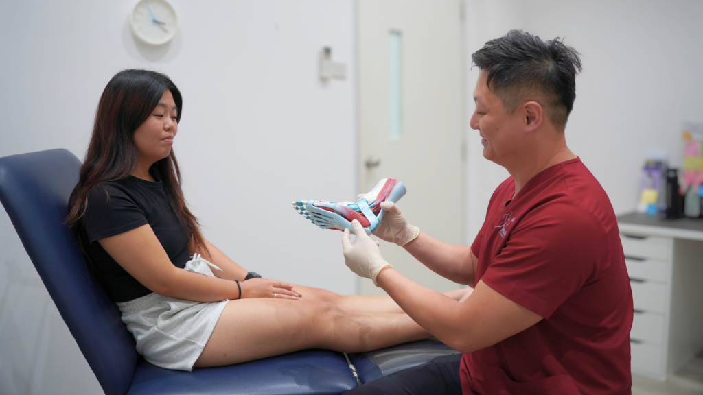 podiatrist explaining foot anatomy and biomechanics to patient during consultation