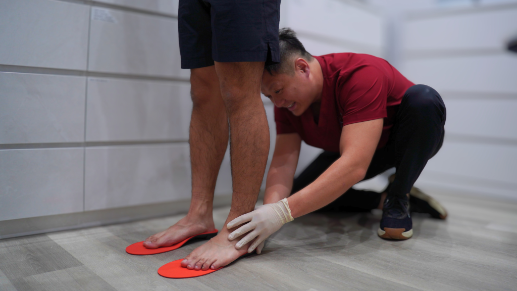 podiatrist assessing foot alignment and fitting orthotic insoles in clinic