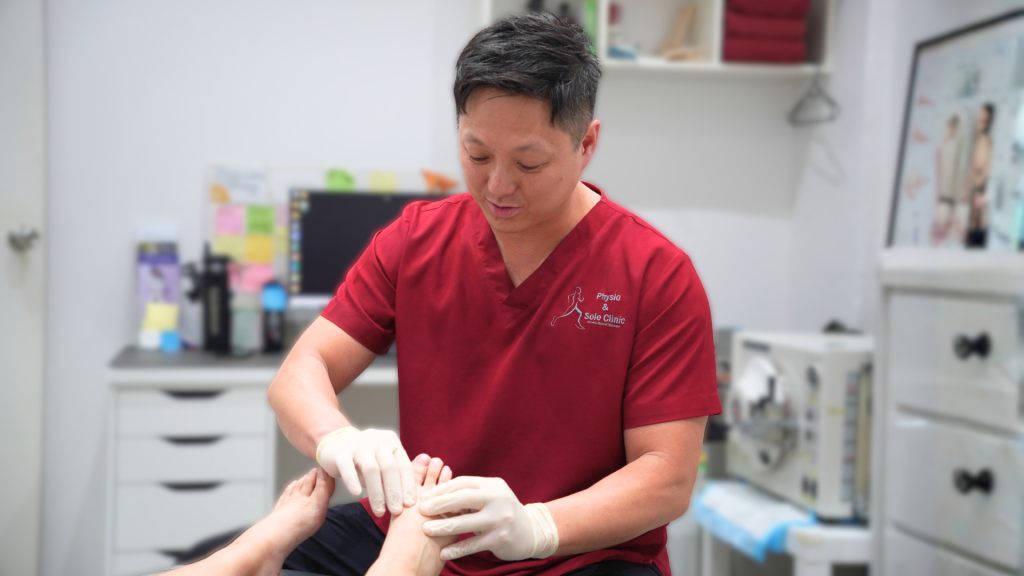 podiatrist treating patient’s foot pain during clinical assessment in Singapore clinic