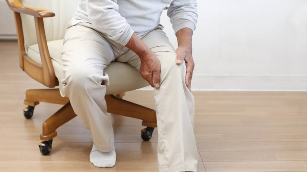 Person holding knee in pain while sitting, illustrating impact of delayed physiotherapy treatment

