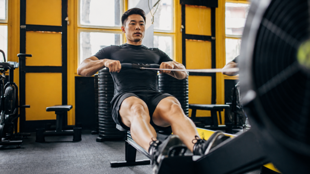 Man performing rowing machine exercise in a gym for upper body strengthening